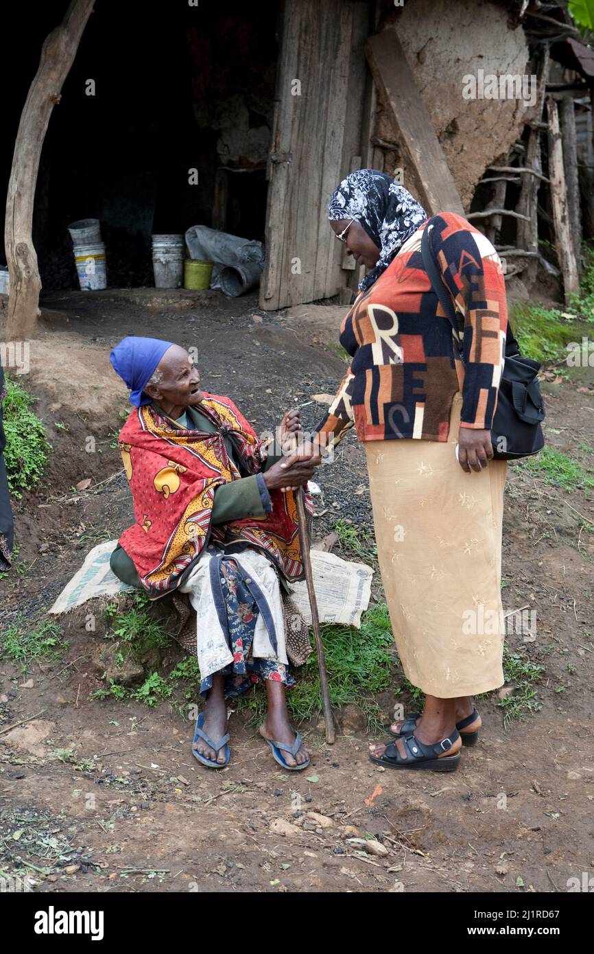 Un assistente saluta un amico locale, Majengo slum, Meru Foto Stock