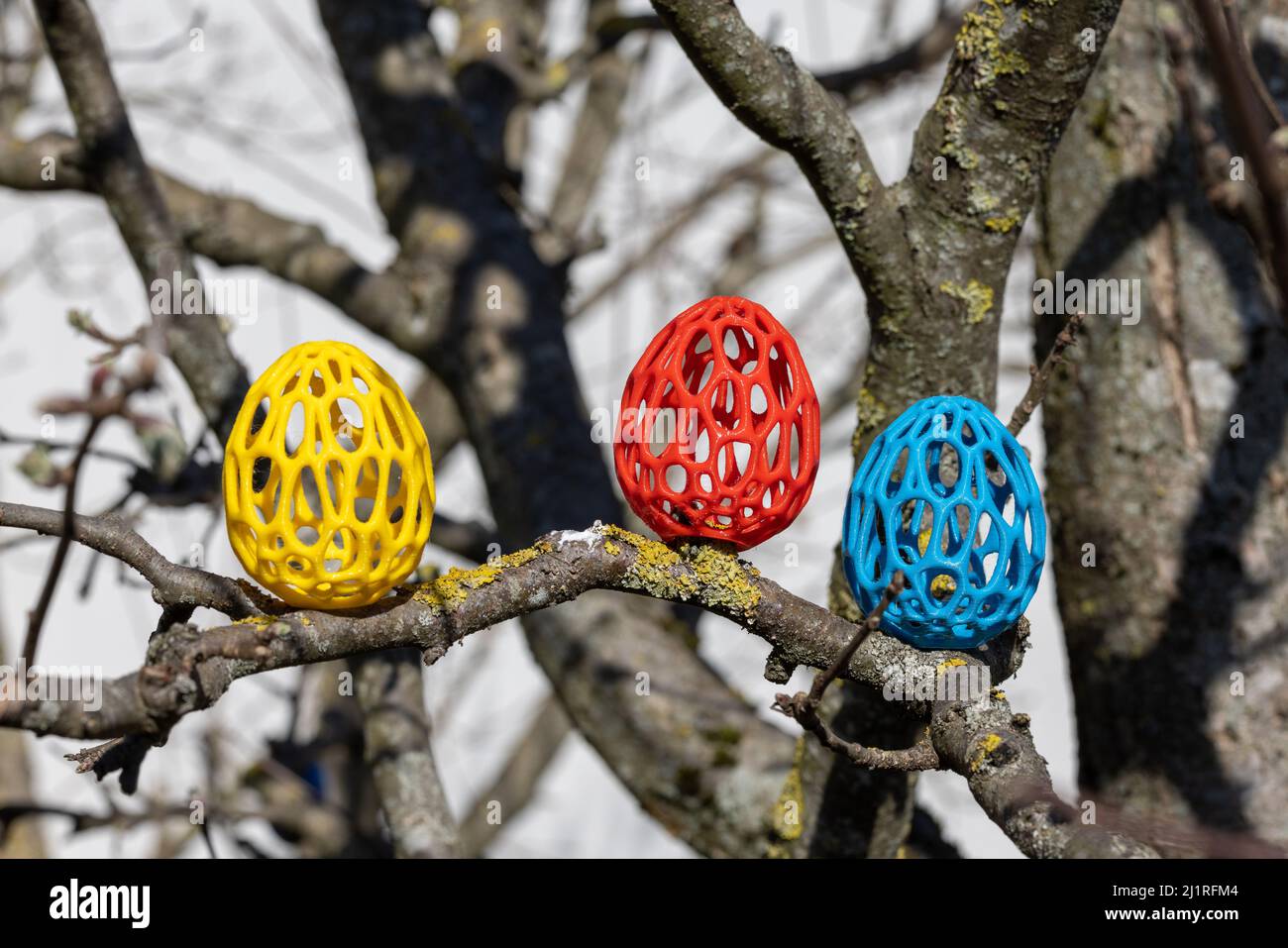 Bunter 3D-Kuststoff Ostereier auf Baum Foto Stock