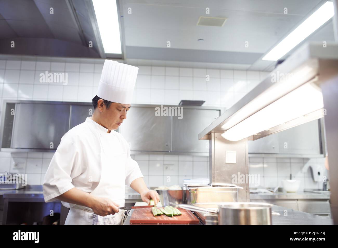 HES uno specialista di sushi. Shot di chef che preparano un servizio di pasto in una cucina professionale. Foto Stock