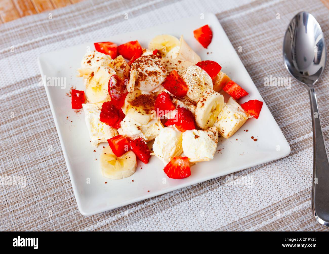 Porzione di gelato con fragole e banane a fette Foto Stock