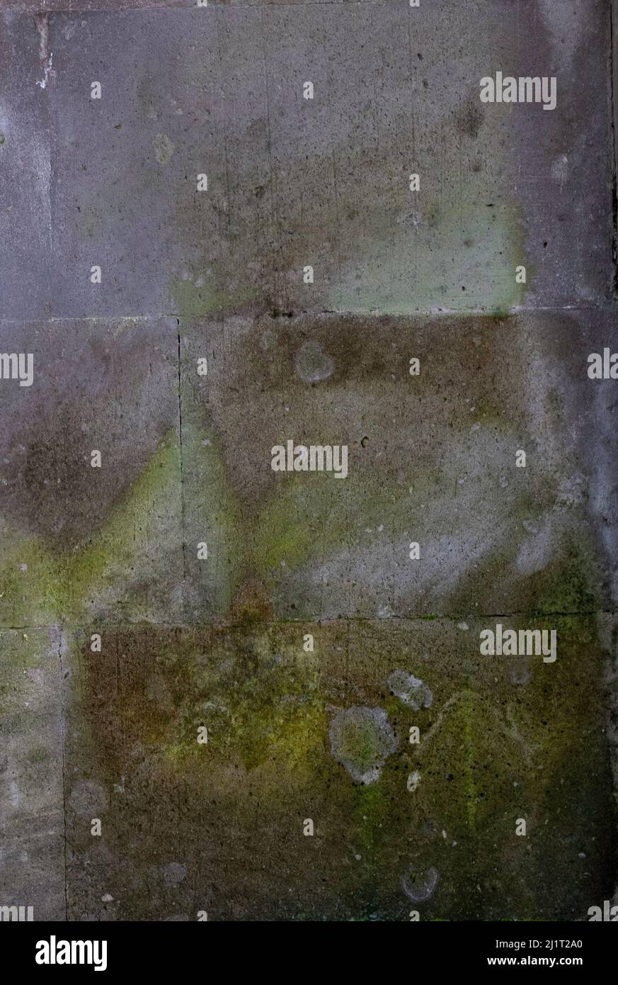 Vecchia parete in cemento multicolore con design naturale da ombreggiature e crepe Foto Stock
