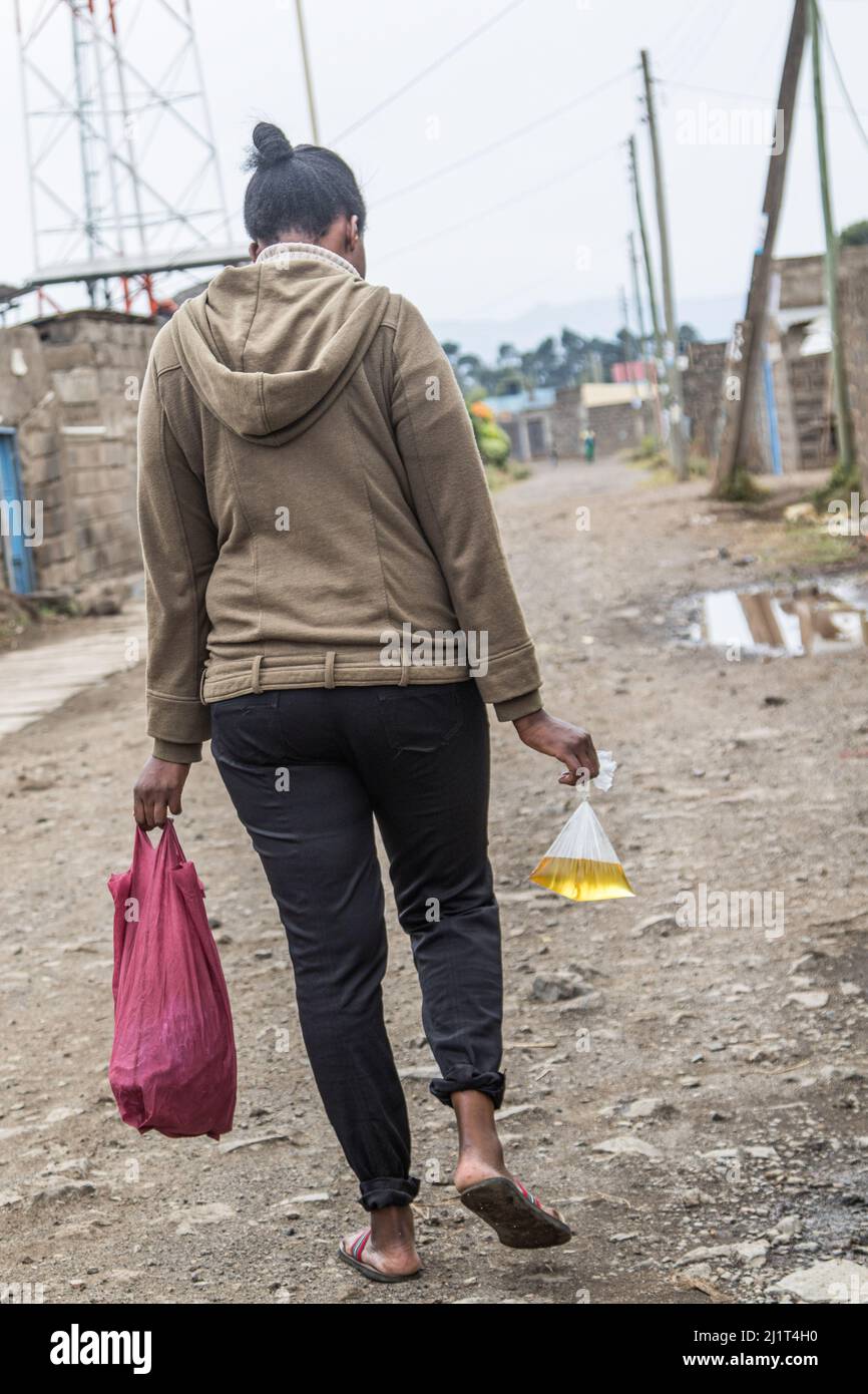 Si vede una giovane donna che porta olio da cucina impaccato in una borsa  di plastica proibita e che rischia l'arresto per aver violato la legge. Il  28 2017 agosto il Kenya