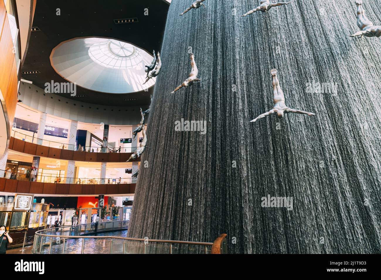 Dubai, Emirati Arabi Uniti - 22 maggio 2021: Vista della cascata con figure di subacquei nel Dubai Mall. Fontana nel centro commerciale di Dubai Pearl Foto Stock