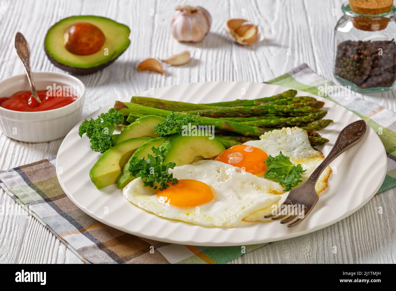 asparagi arrostiti, avocado maturo e uova fritte Foto Stock