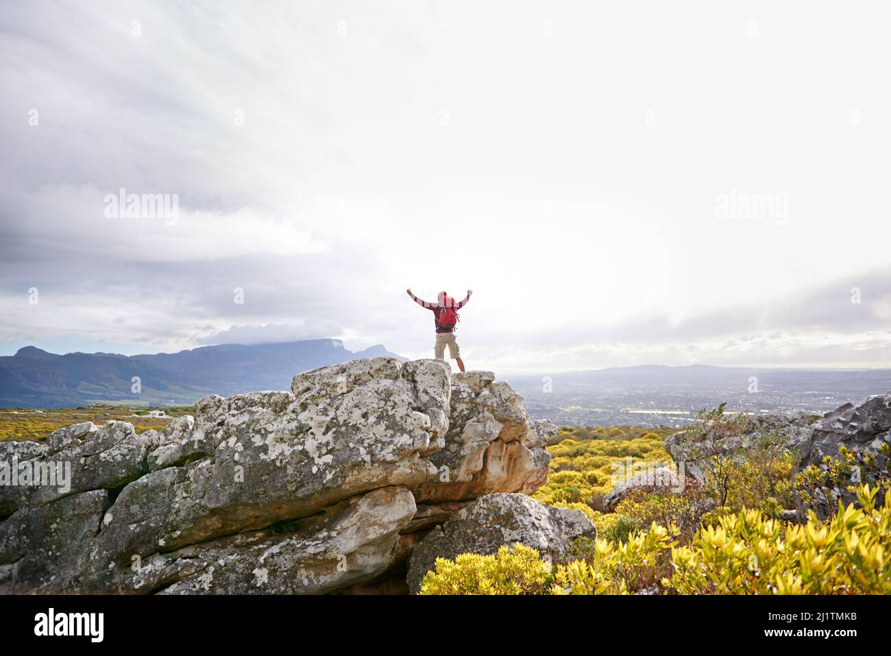 Nessun ostacolo è troppo grande. Scatto di un uomo in cima a una montagna accidentata. Foto Stock