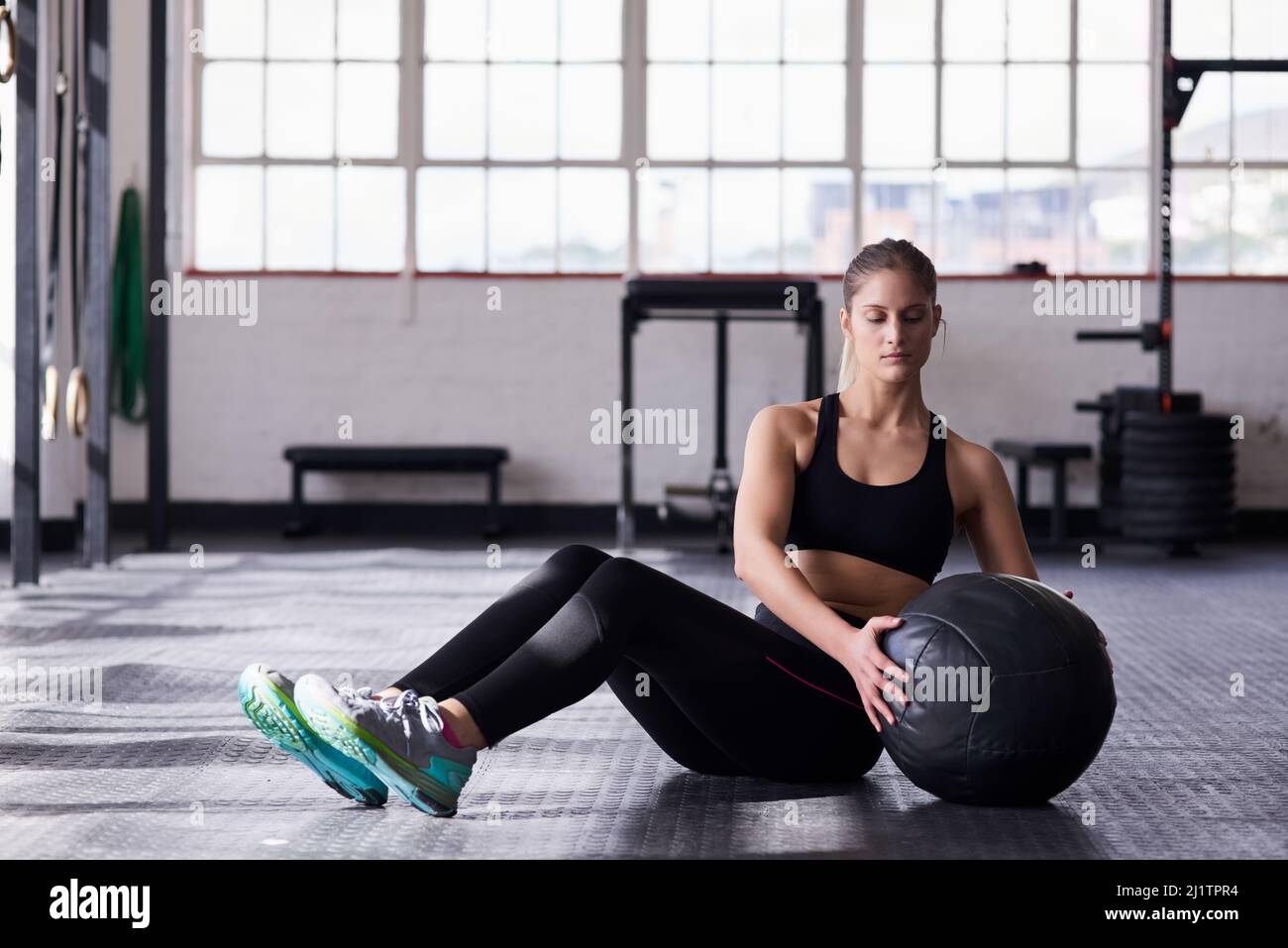 Siete alla ricerca di un grande allenamento tonificante dello stomaco. Shot di una giovane donna utilizzando una palla medica in una routine di esercizio. Foto Stock