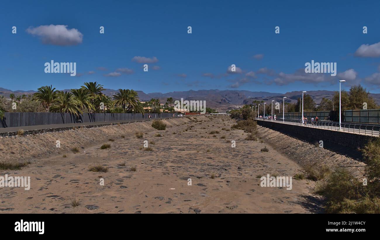 Vista del canale vuoto a Meloneras l'ovest della località turistica Maspalomas, Gran Canaria, Spagna in giornata di sole nella stagione invernale circondato da palme. Foto Stock