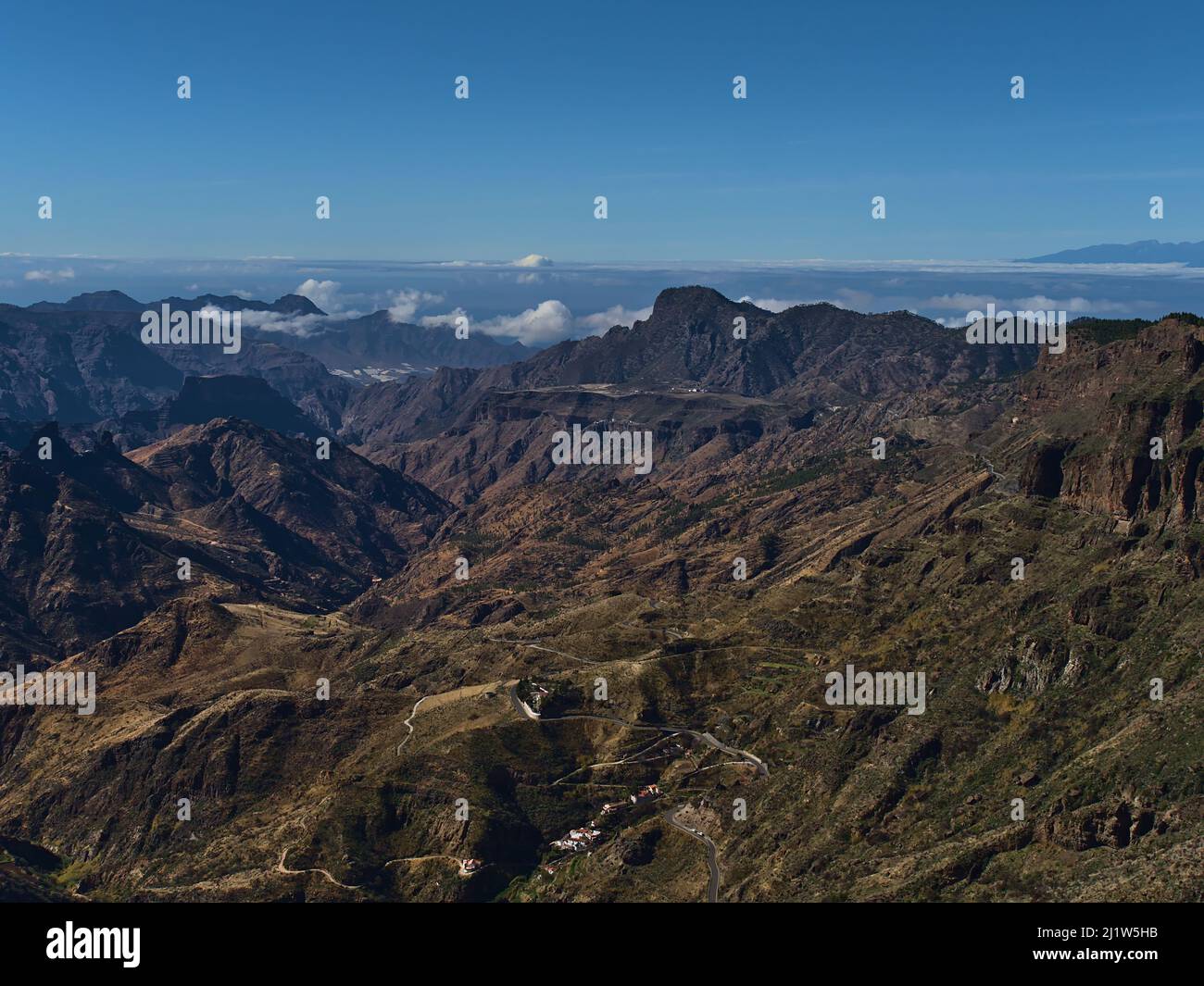 Bella vista aerea delle montagne occidentali dell'isola di Gran Canaria, Isole Canarie, Spagna in giornata di sole nella stagione invernale con tortuosa strada di campagna. Foto Stock