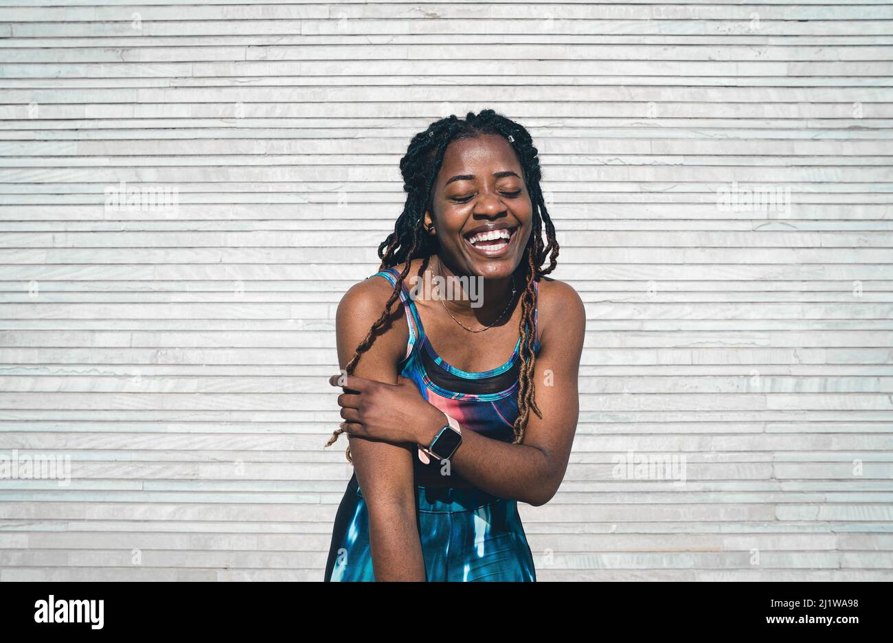 Ridendo afroamericana donna in sportswear in piedi dopo la pratica di idoneità Foto Stock