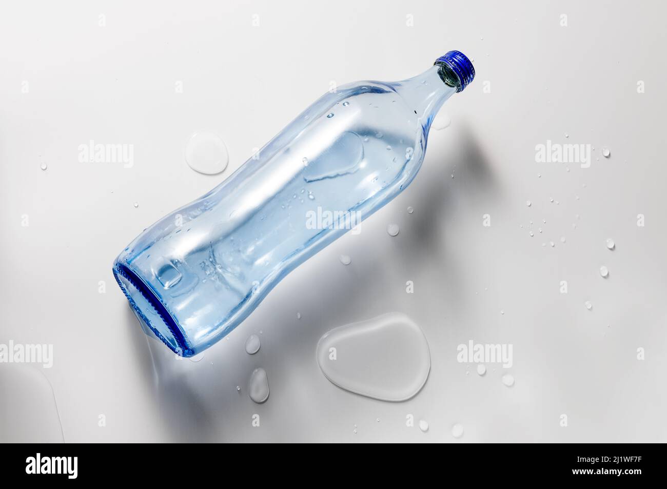 Vista dall'alto della bottiglia d'acqua in vetro isolata su sfondo bianco. Foto Stock