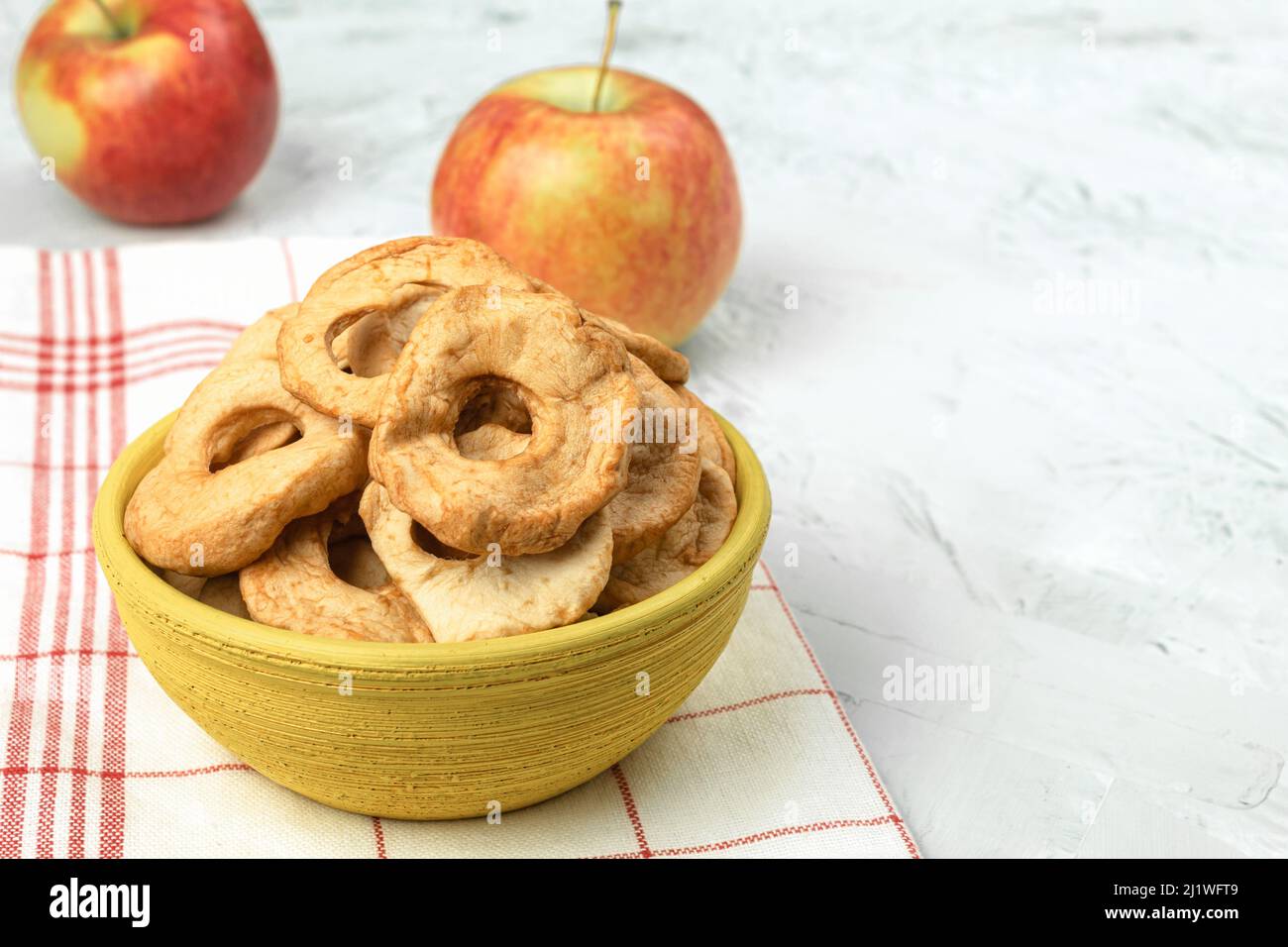 Mele fresche e mele secche sul tavolo. Sfondo con spazio di copia. Concetto artistico di cibo sul piano di lavoro della cucina Foto Stock