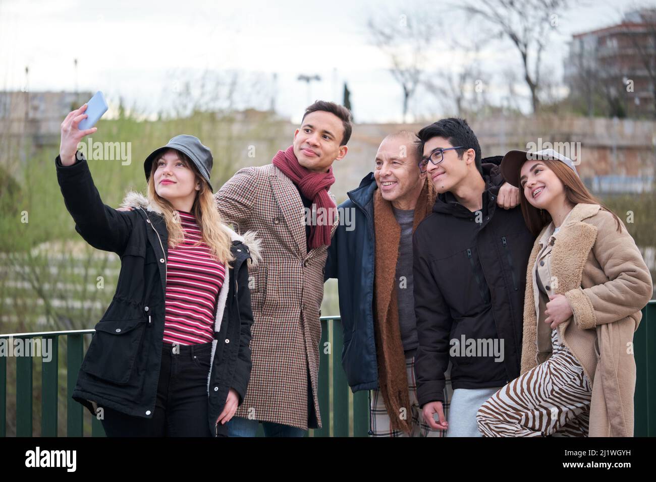 Gruppo di amici di diverse età ed etnie che prendono un selfie all'aperto. Foto Stock