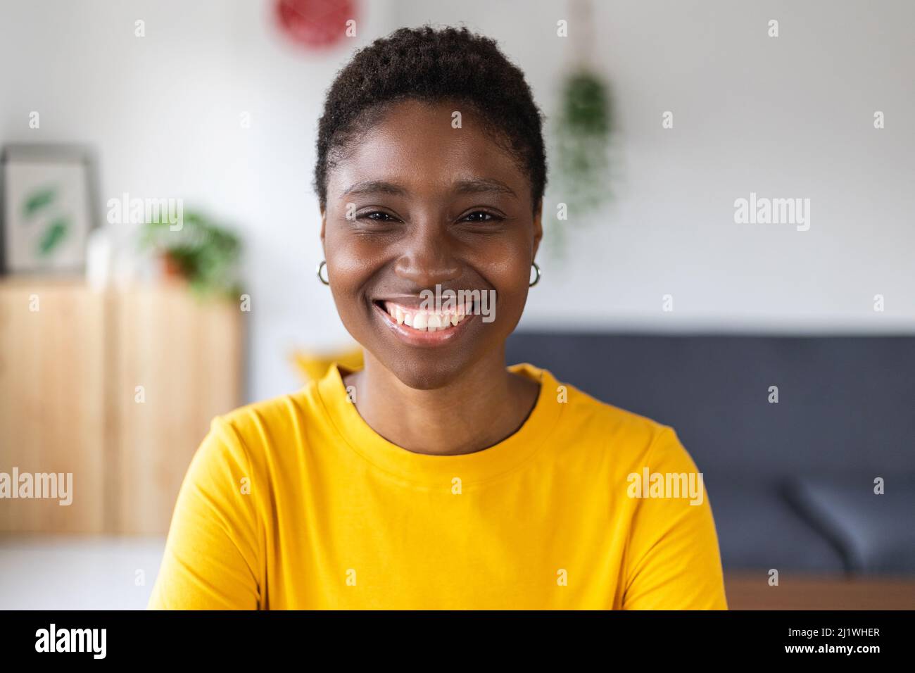 Schermo ritratto di sorridente donna africana millenaria in videochiamata a casa Foto Stock