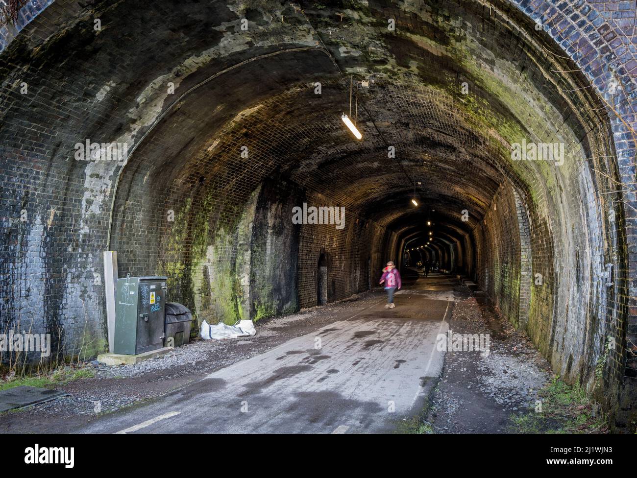 Camminatore femminile nel tunnel della lapide lungo il sentiero Monsal, Derbyshire. Foto Stock