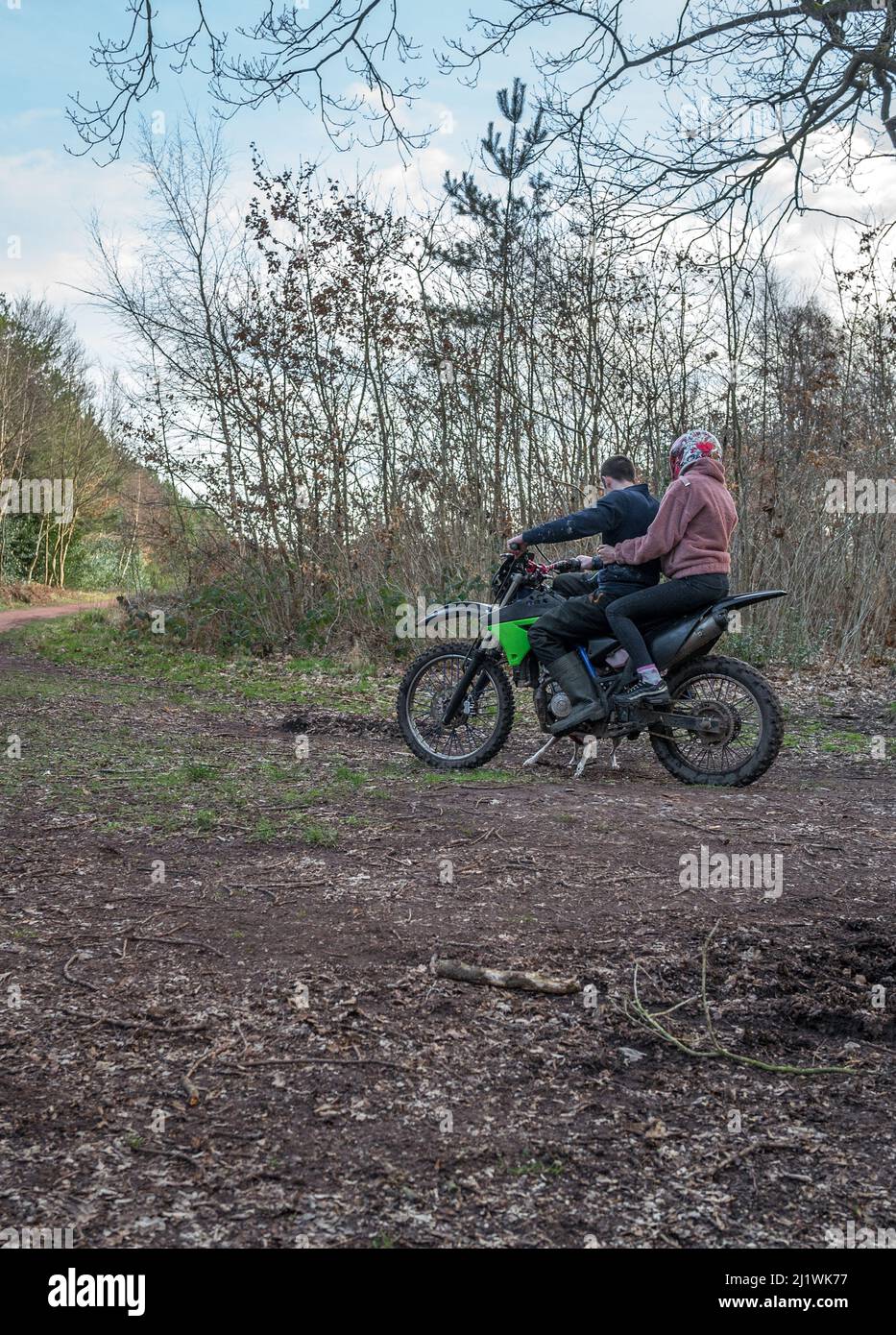 Uomo che guida una moto fuoristrada con passeggero illegalmente lungo un sentiero pubblico. Foto Stock