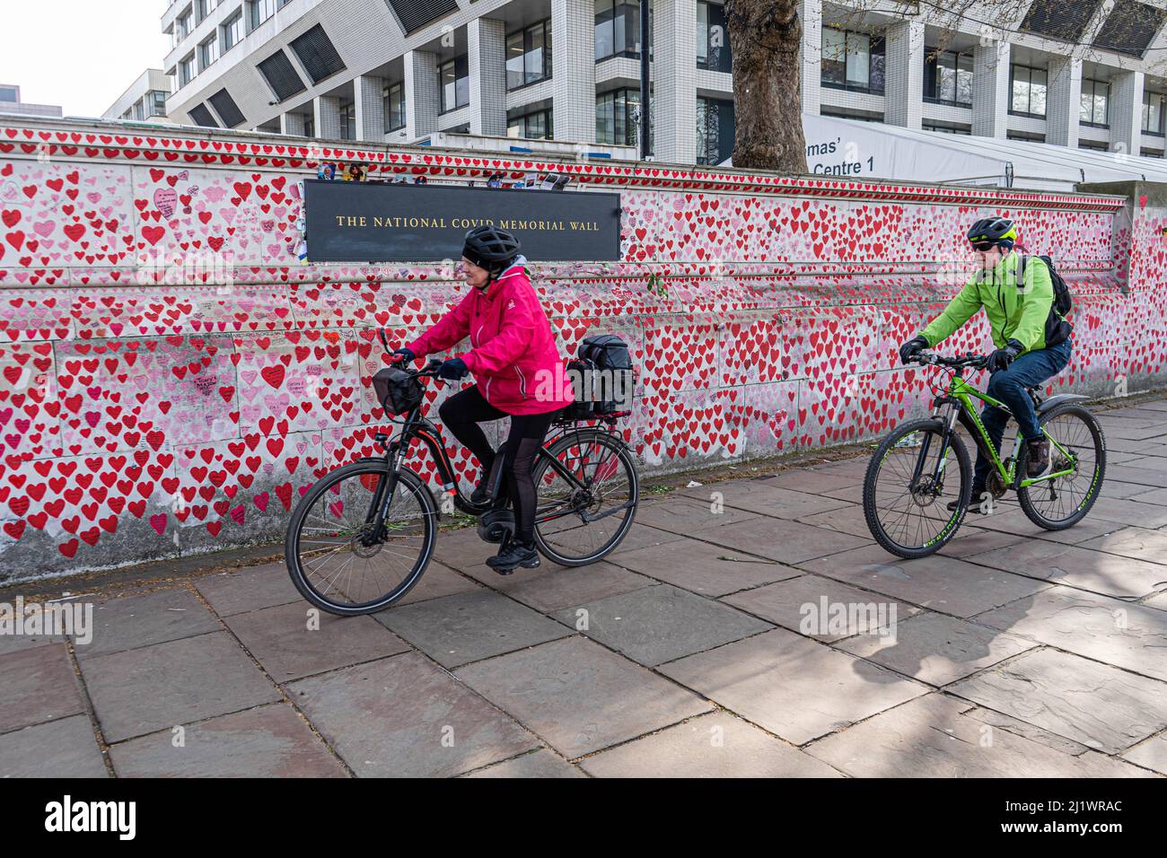 LONDRA, REGNO UNITO. 28 marzo 2022. Due ciclisti che cavalcavano i cuori dipinti alla cinta muraria nazionale per ricordare le vittime della pandemia del coronavirus. Secondo i dati dell'Ufficio per le statistiche nazionali in Inghilterra si è registrato un aumento del numero di casi causati dalla variante Omicron BA.2 un virus ricombinante che contiene elementi delle varianti Delta e Omicro in quanto il numero di infezioni COVID-19 è salito a 4,26 milioni nei sette Giorni al 19 marzo - aumento del 29,7% sulla settimana prima. Credit: amer Ghazzal/Alamy Live News Foto Stock