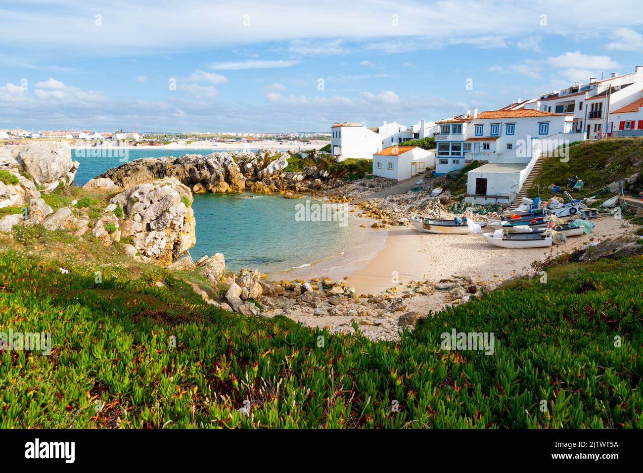 Bella insenatura di pescatori con le barche da pesca sulla sabbia e Baleal spiaggia sul retro a Peniche Foto Stock