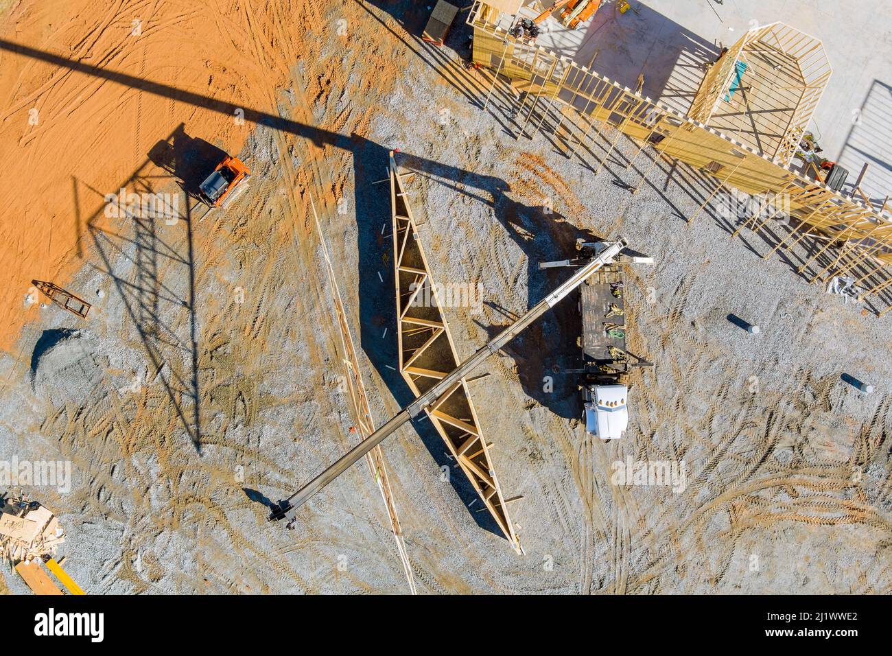 La costruzione con gru tiene in dettaglio una costruzione di tralicci di tetto in legno sovrapposizione una vista dall'alto Foto Stock