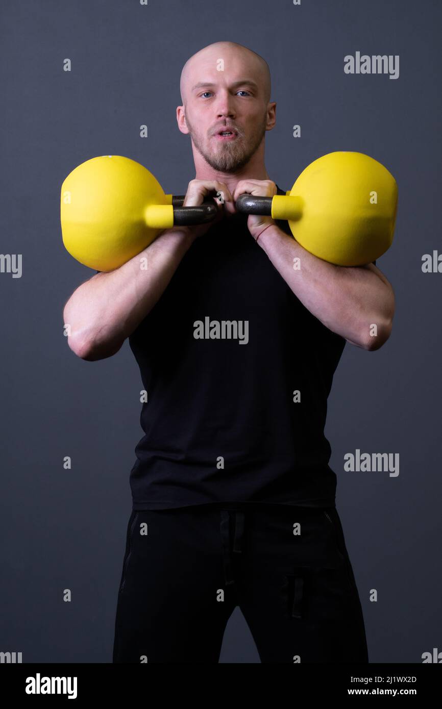 Ragazzo con un gym kettlebell giallo anonimo uomo giallo, per la motivazione stile di vita per gli uomini per la gioventù, fitness malese. Resistenza a intervalli sani Foto Stock