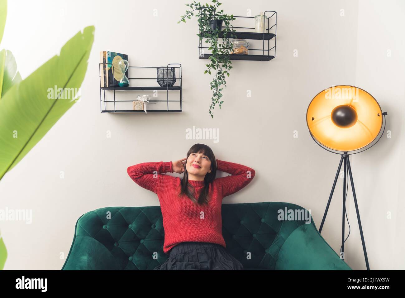 Bella donna caucasica rilassante da sdraiato su un divano a casa. Concetto di individualità. Foto di alta qualità Foto Stock