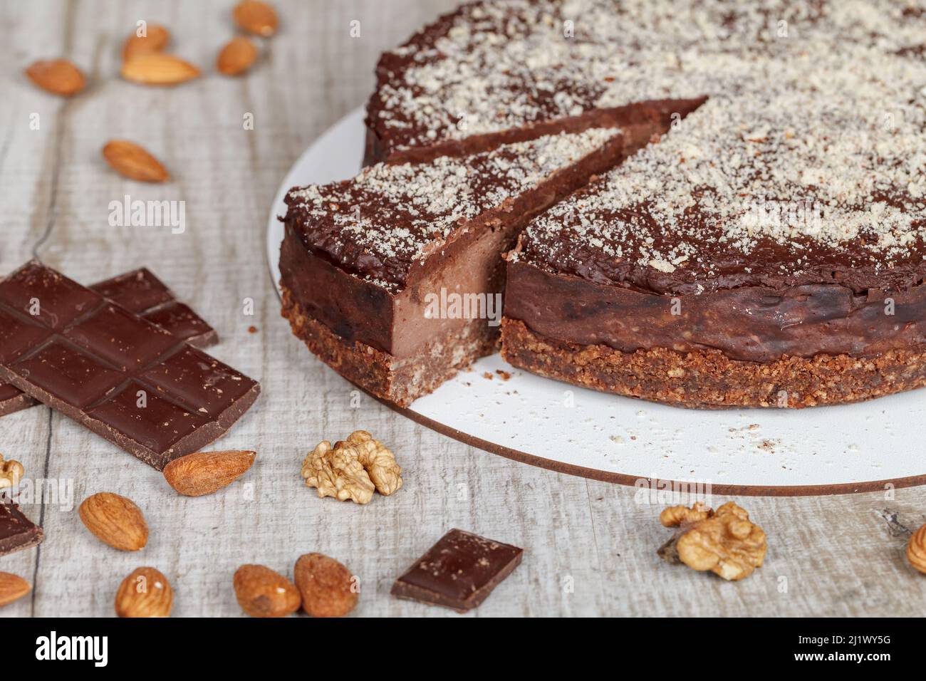 Torta al cioccolato con un pezzo tagliato su sfondo grigio, primo piano Foto Stock