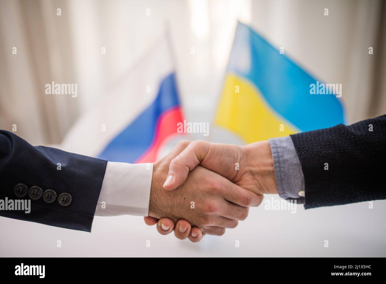 I rappresentanti dell'Ucraina e della Russia scuotono le mani, concetto di accordo di pace dell'Ucraina. Foto Stock