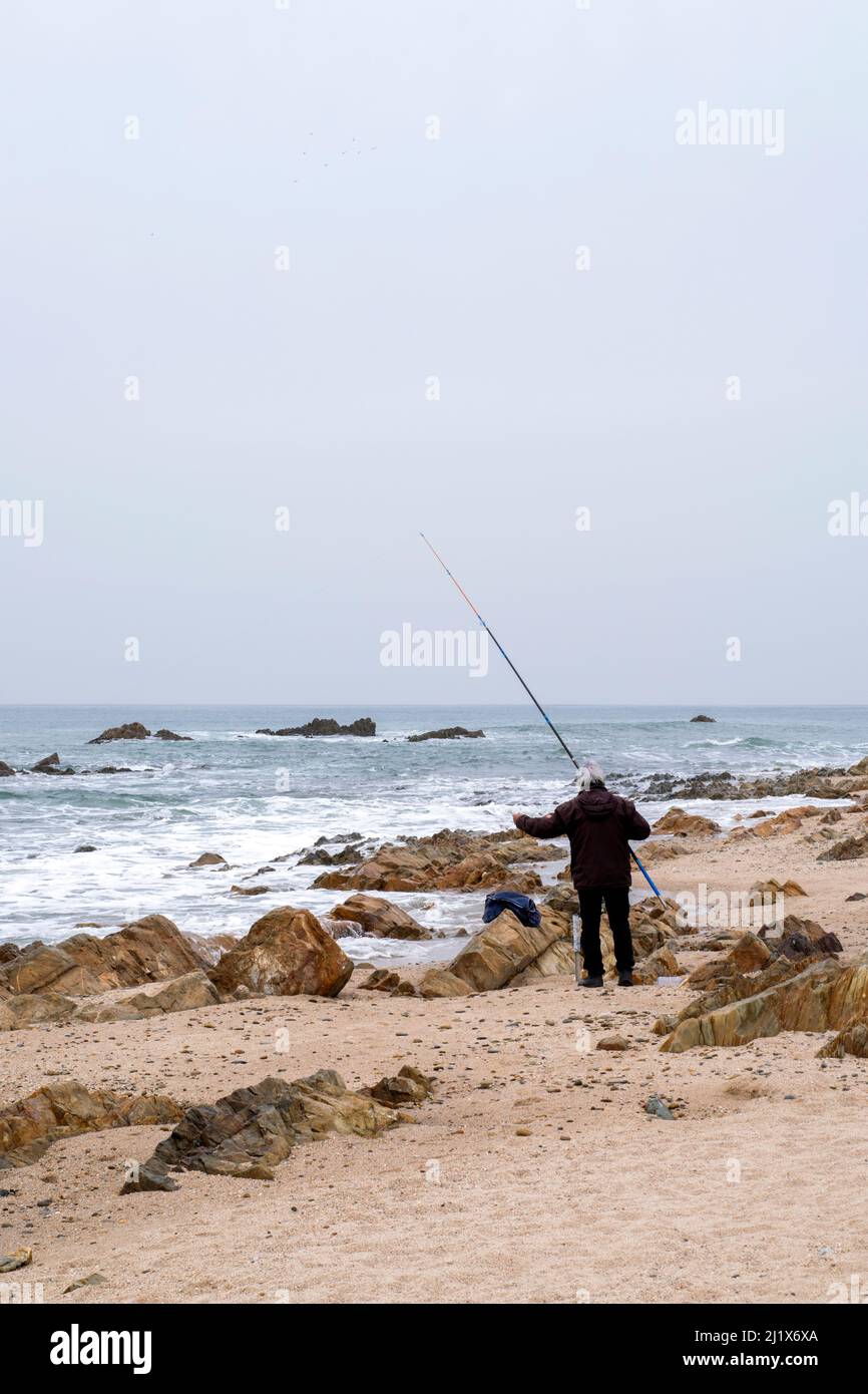 Adulto maschio o uomo sulla spiaggia, divertente pesca in spiaggia. Hobby di pesca, la pesca è uno sport sano per pensionamento. Canna da pesca in spiaggia. Foto Stock