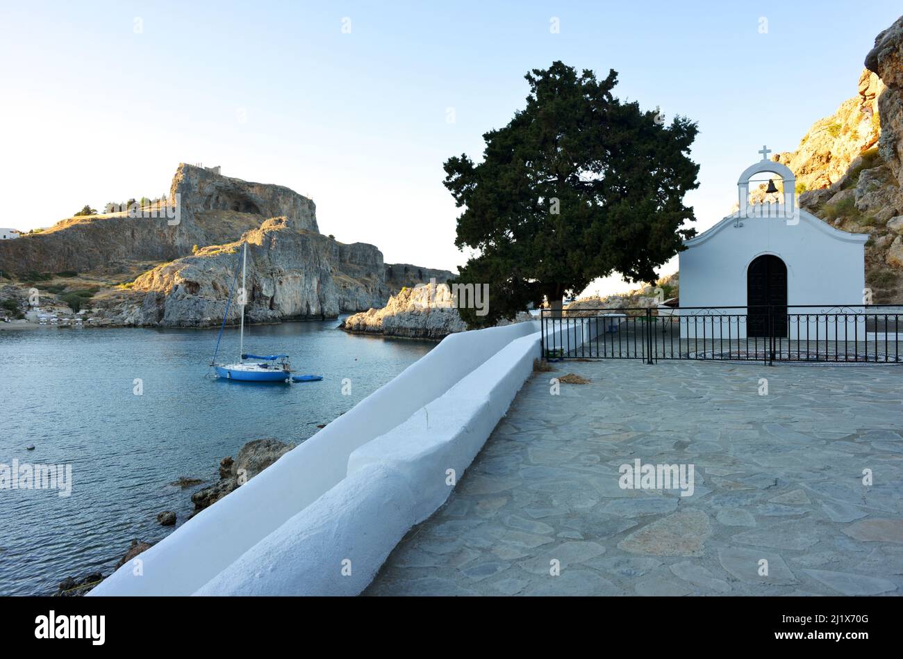 Lindos, Grecia St. Pauls Bay Chapel vista per l'acropoli e la baia rocciosa Foto Stock