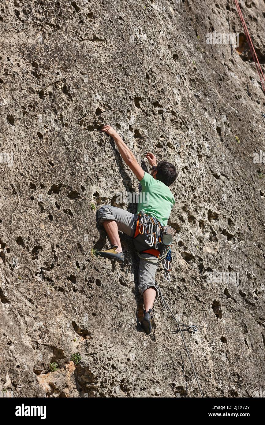 Arrampicatore su una parete di granito. Sport estremo. Attività di montagna all'aperto Foto Stock