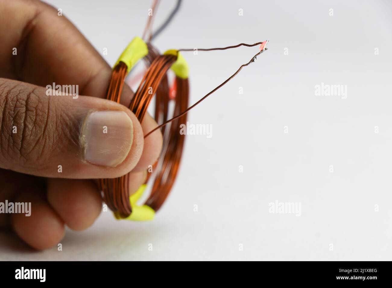 Prototipo del progetto di trasmissione wireless di energia elettrica tenuto in mano su sfondo bianco Foto Stock