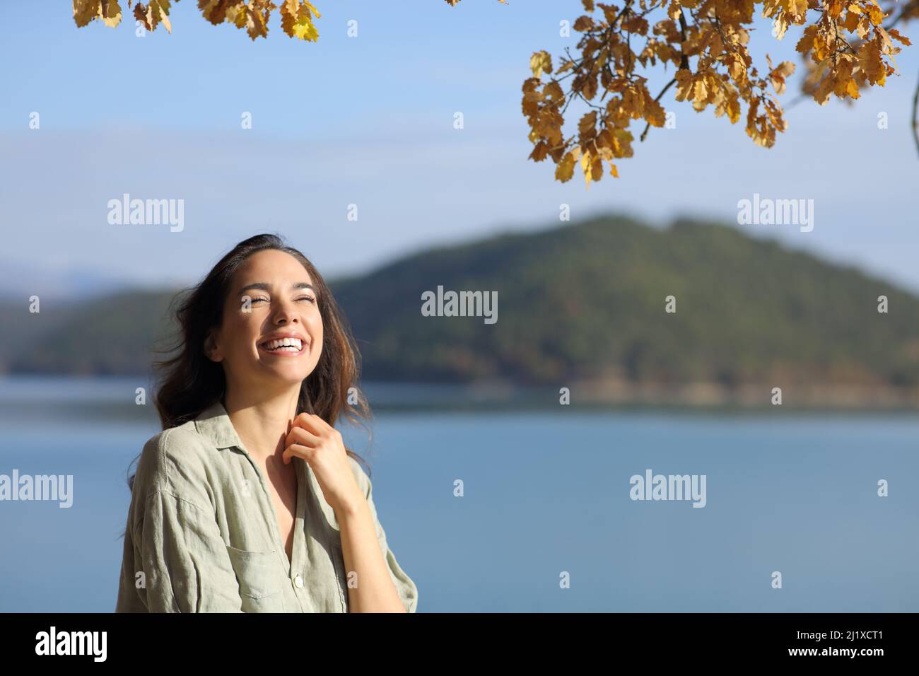 Donna divertente guardando in su in un lago bello in vacanza con spazio di copia Foto Stock