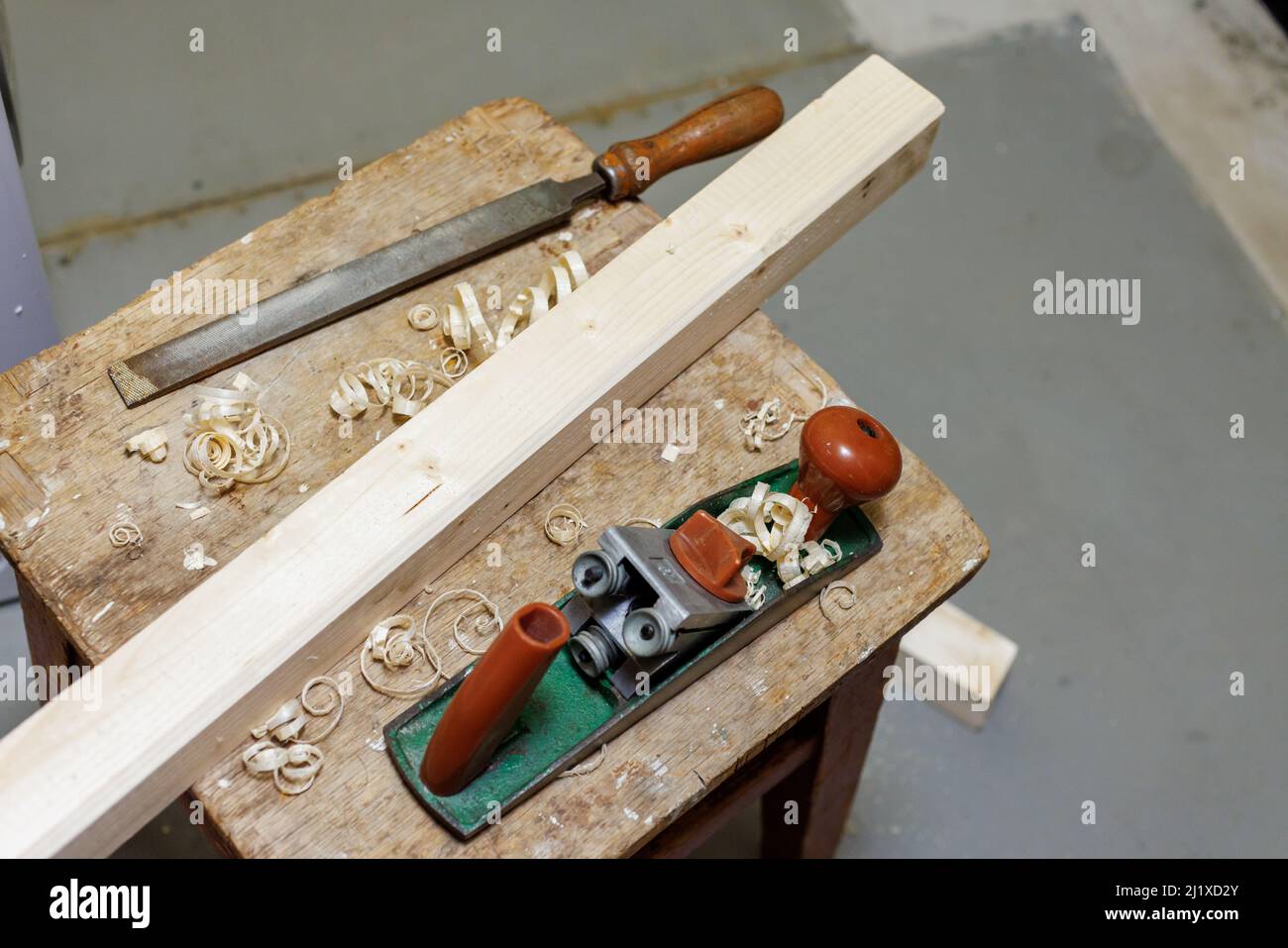 piallatrice, lima e blocco di legno su uno sgabello Foto Stock