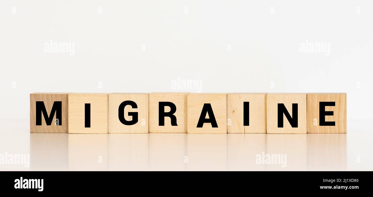 Parola di emicrania scritta su blocco di legno, concetto medico Foto Stock