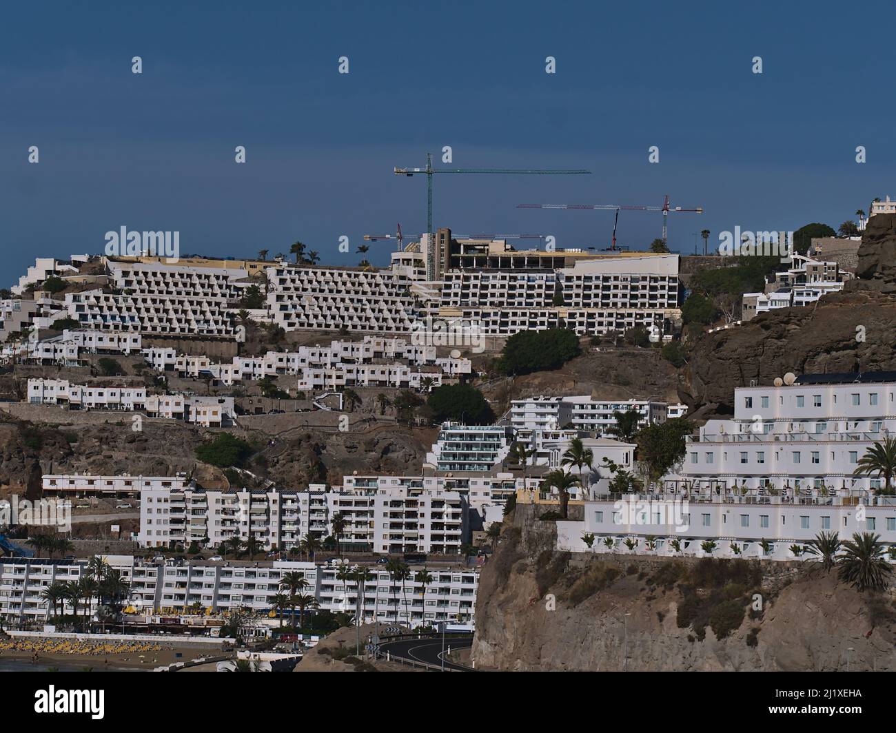 Vista di grandi e brutti edifici alberghieri sulle colline della località turistica Puerto Rico de Gran Canaria, Isole Canarie, Spagna sulla costa atlantica in giornata di sole. Foto Stock