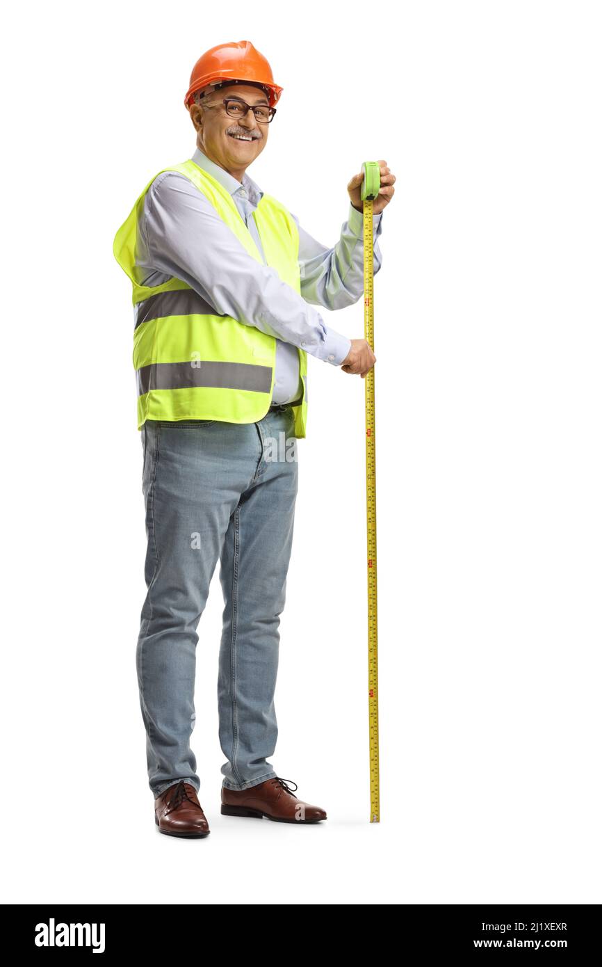 Scatto completo di un ingegnere maschio maturo utilizzando un metro a nastro in acciaio isolato su sfondo bianco Foto Stock
