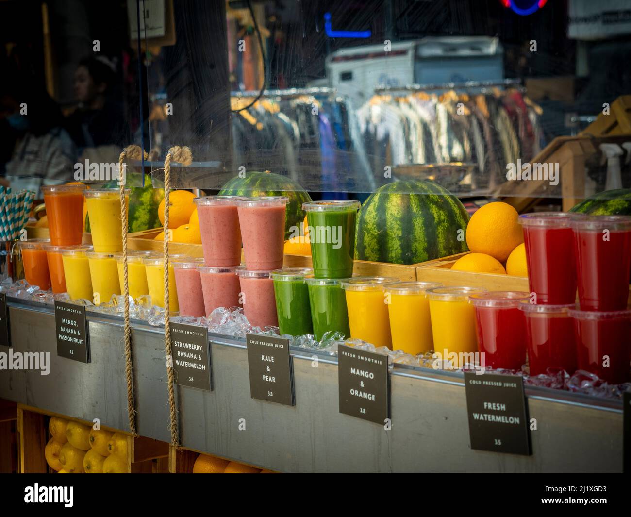 Succhi e frullati in tazze monouso in plastica in mostra presso un juice bar. Foto Stock