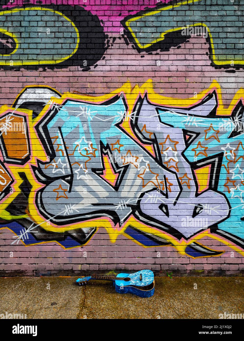 Gray Eagle Street graffiti con chitarra blu rotta in primo piano. Spitalfields zona di Londra. Foto Stock