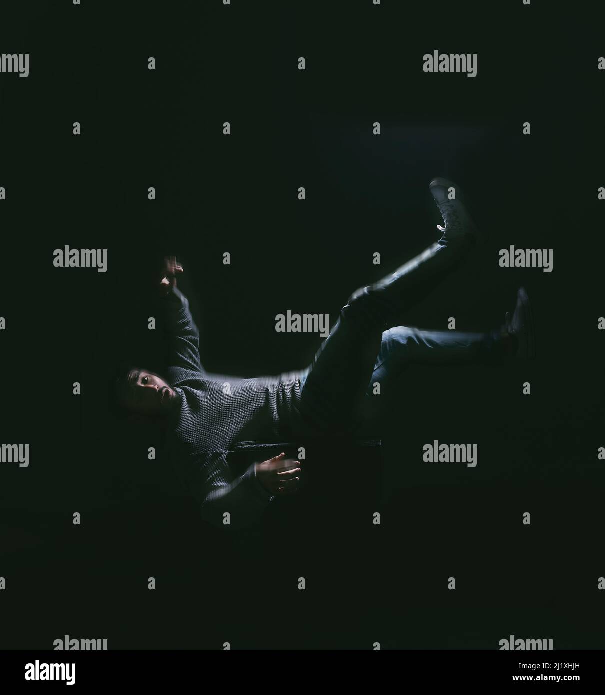 Cadere il tuo sogno thats paura di perdere il controllo. Colpo di un giovane che cade su uno sfondo scuro. Foto Stock