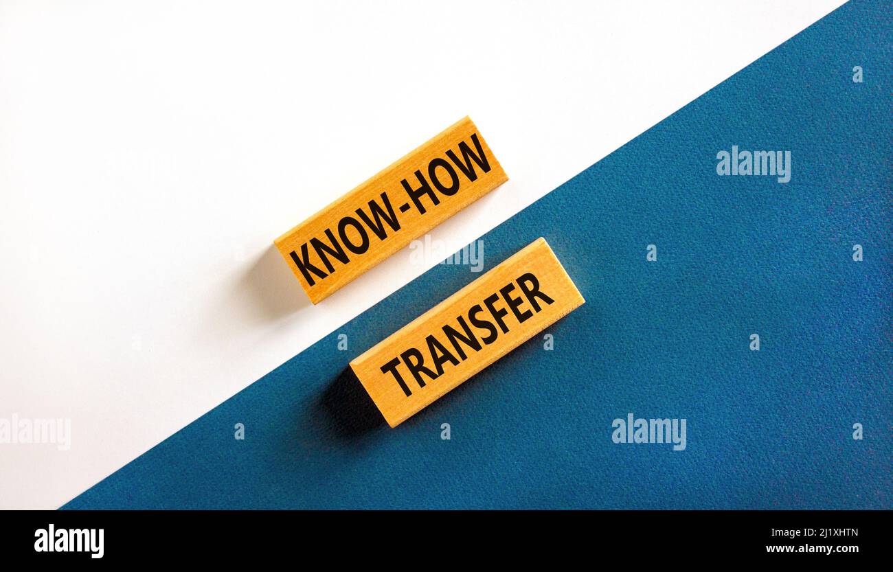 Simbolo di trasferimento del know-how. Concetto parole know-how trasferimento su blocchi di legno su bello sfondo bianco tabella blu. Spazio di copia. Innovazione aziendale A. Foto Stock