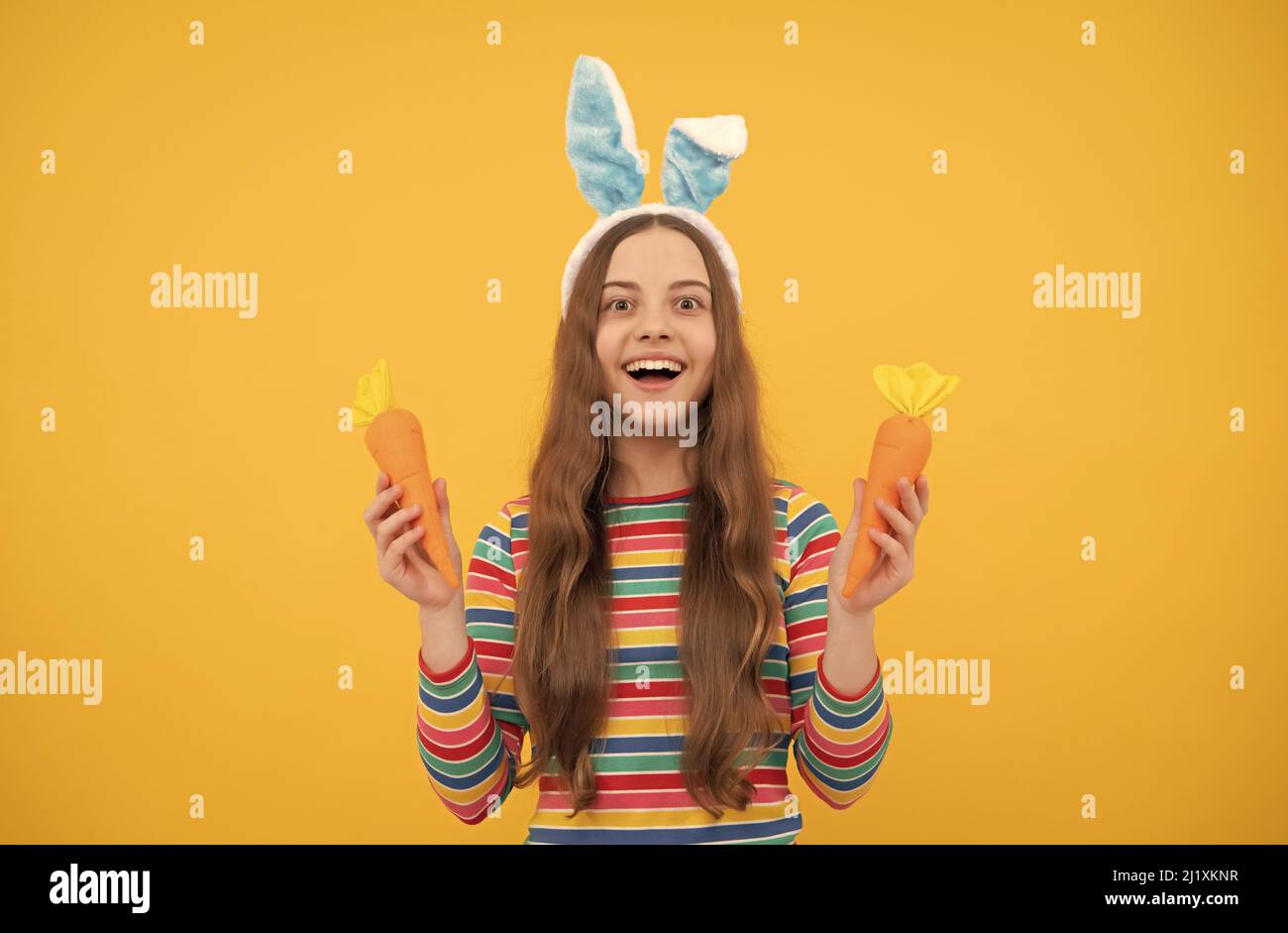 buona pasqua ragazza teen in coniglio coniglietto orecchie tenendo carota per le vacanze, caccia coniglietto Foto Stock