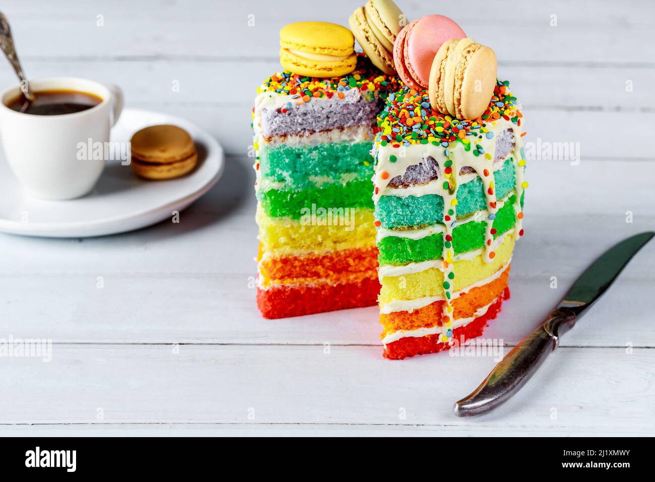Gustosa torta festiva decorata con biscotti macaroon e tazza di caffè. Foto Stock