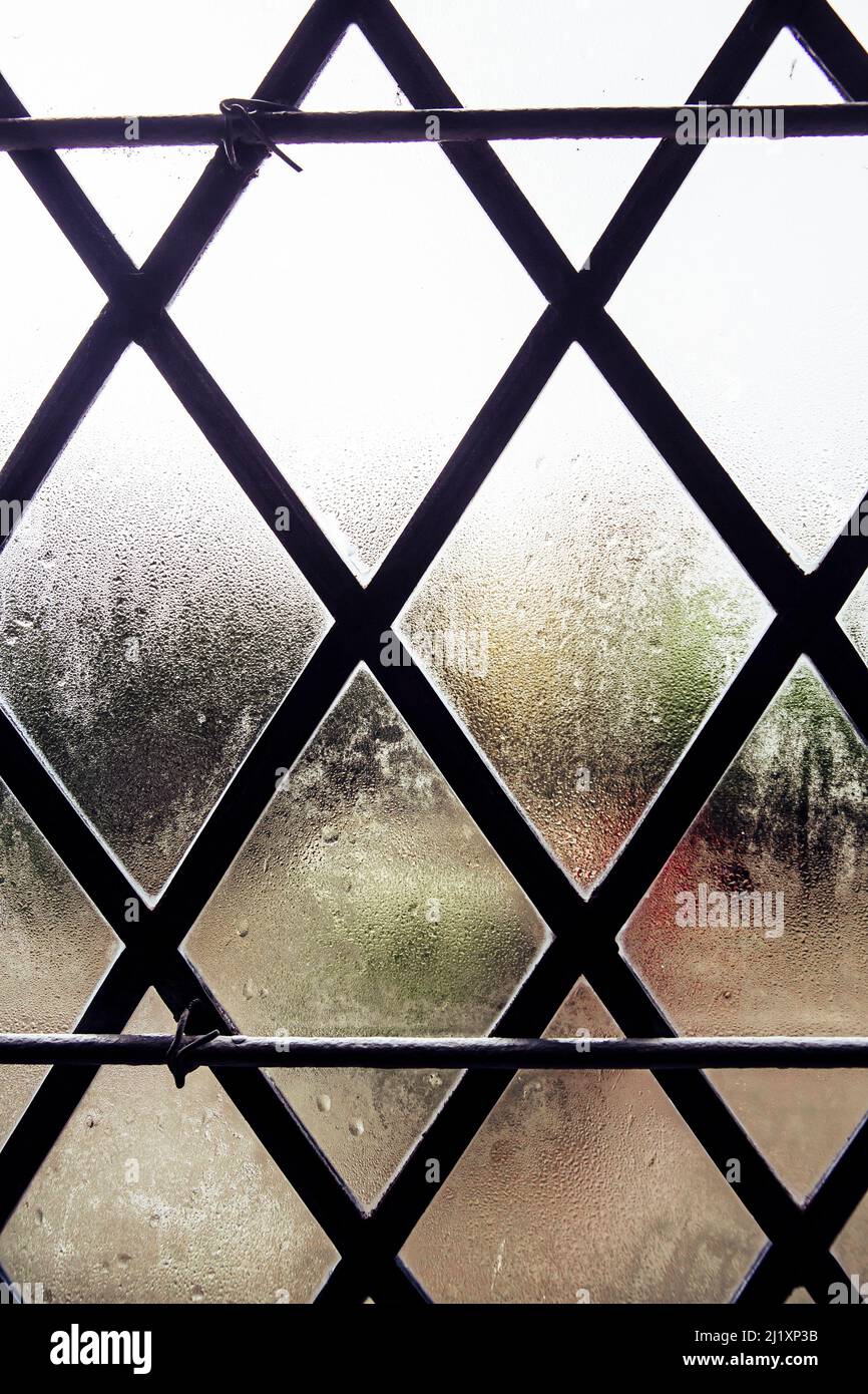 Una vecchia finestra a piombo con condnimento sul vetro. Foto Stock