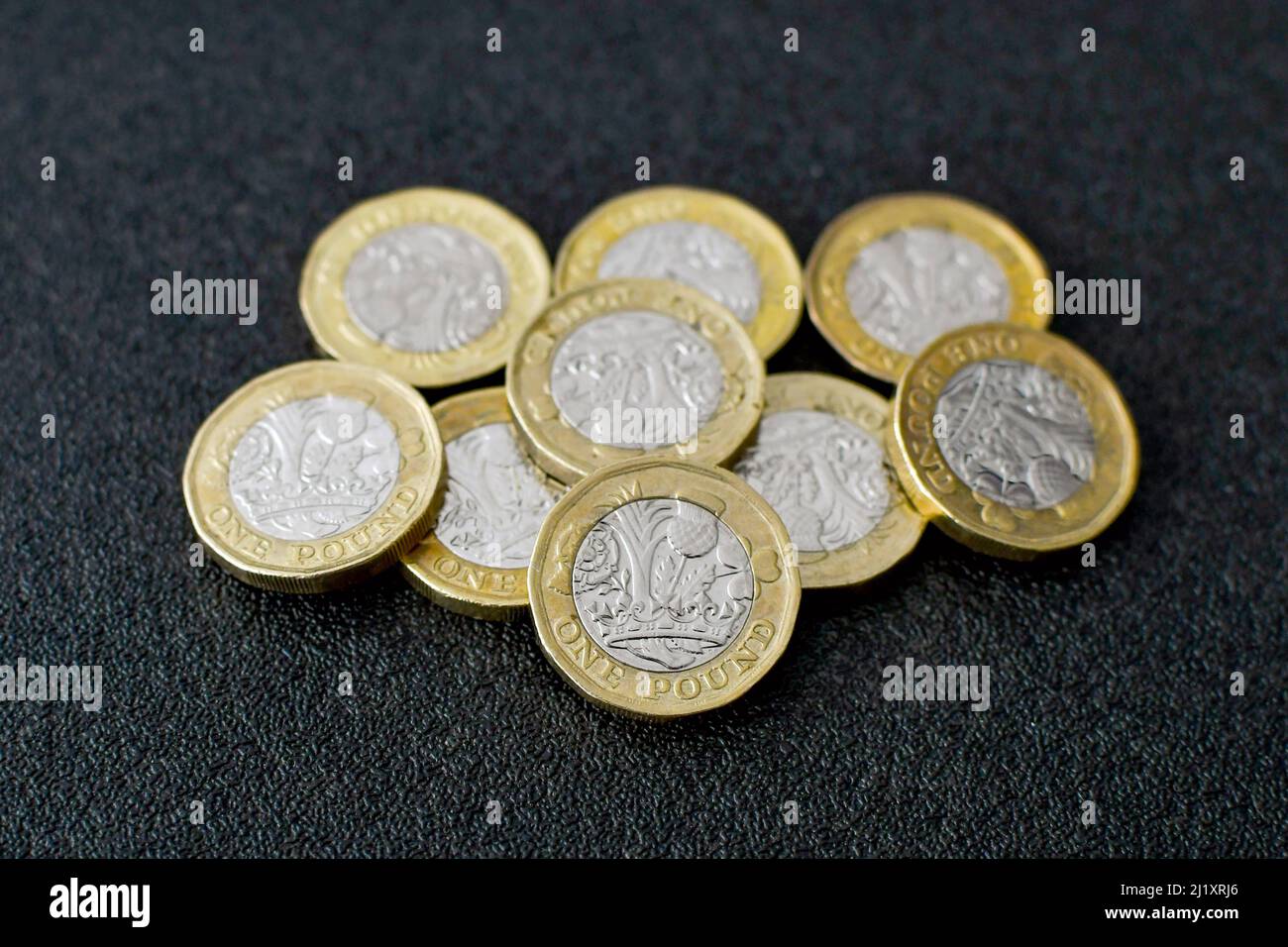 Vista ravvicinata delle monete britanniche da 1 libbra su sfondo nero. Nessuna gente. Foto Stock