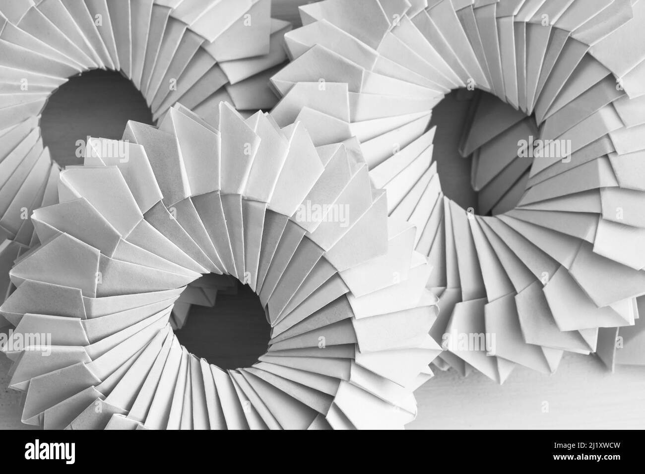 Anelli di origami bianchi. Oggetti parametrici astratti costituiti da fogli di carta collegati Foto Stock