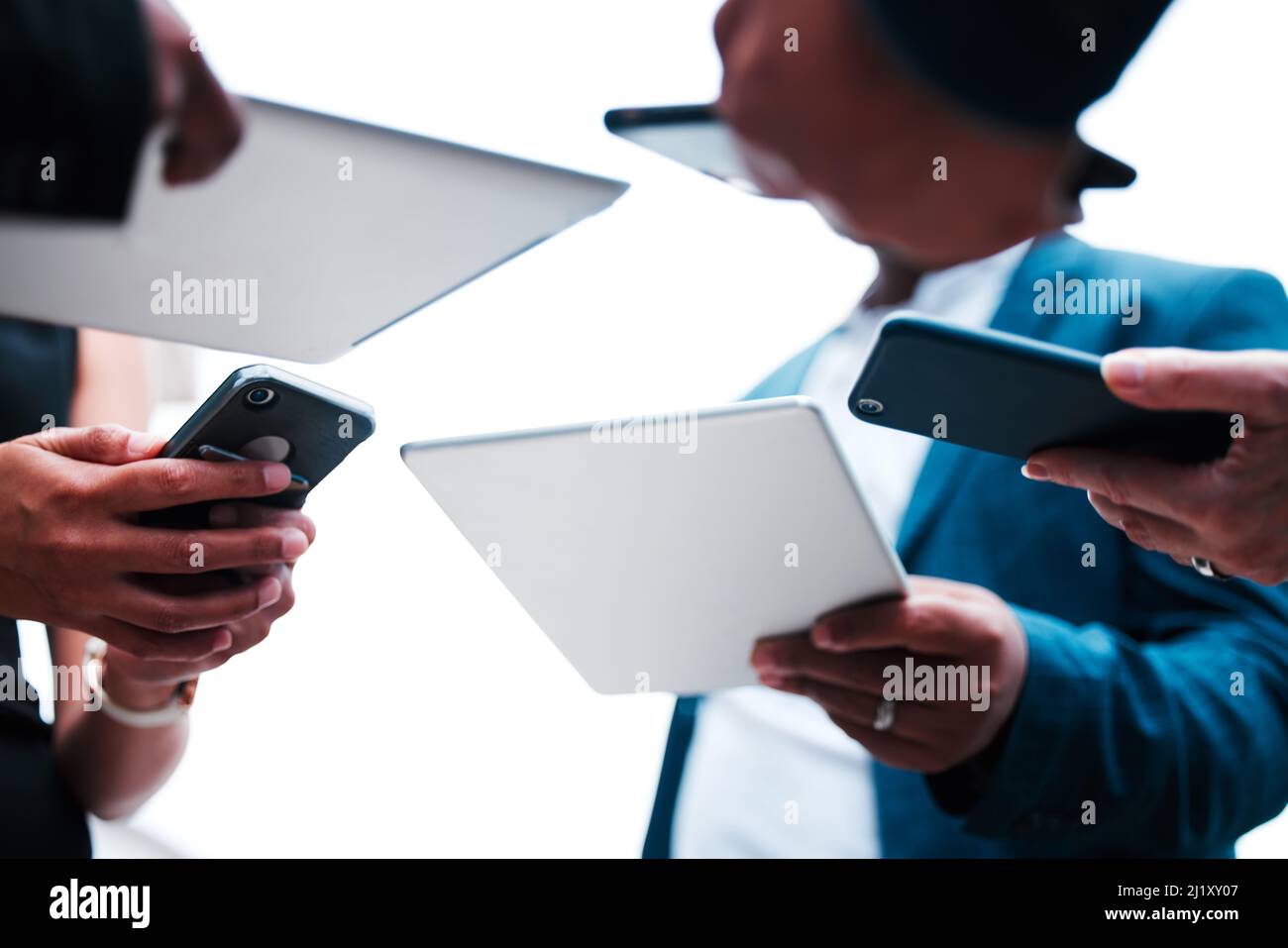 Insieme alla tecnologia. Sotto la foto di un gruppo di uomini d'affari irriconoscibili che utilizzano i loro dispositivi mobili. Foto Stock