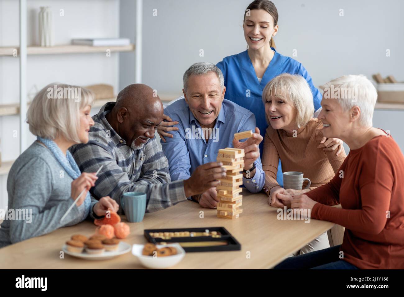 Felice gruppo multirazziale di pensionati che giocano a giochi da tavolo Foto Stock