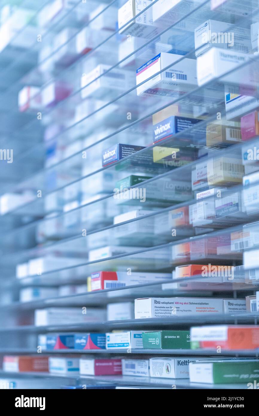 Una stanza di deposito della farmacia, i farmaci stanno disponendo e immagazzinati su una mensola di vetro in una farmacia.tolse fuori con una mano del robot Foto Stock