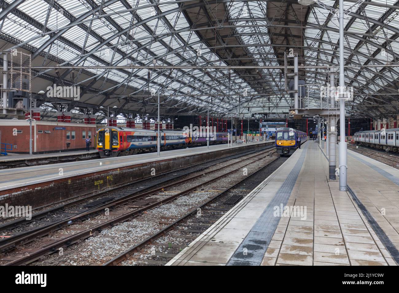Stazione ferroviaria di Liverpool Lime Street con treno elettrico Northern Rail classe 319 e treno sprinter diesel East Midlands classe 158 Foto Stock