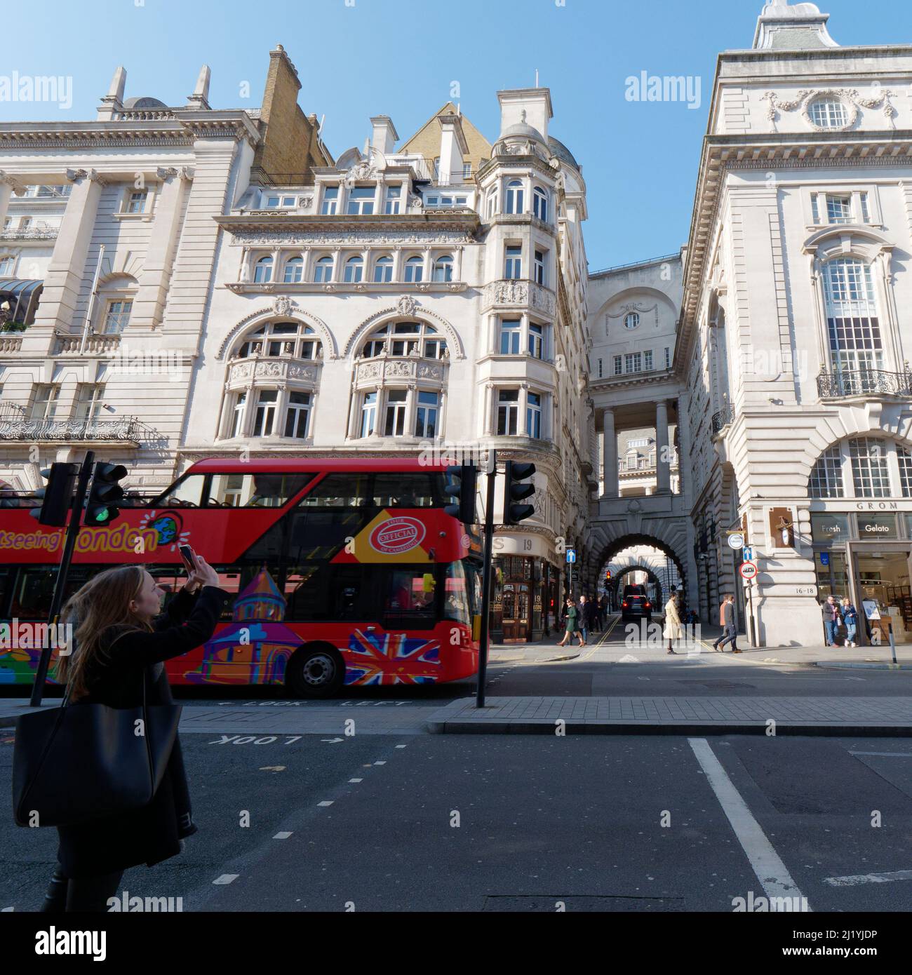 Londra, Greater London, Inghilterra, marzo 08 2022: Il turista scatta una foto su Regent Street guardando verso Air Street come un punto di vista che vede l'autobus passa vicino. Foto Stock