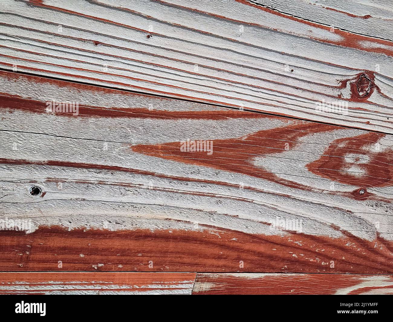 Primo piano di vernice sbiadita marrone-rossastra su legno intemperato Foto Stock